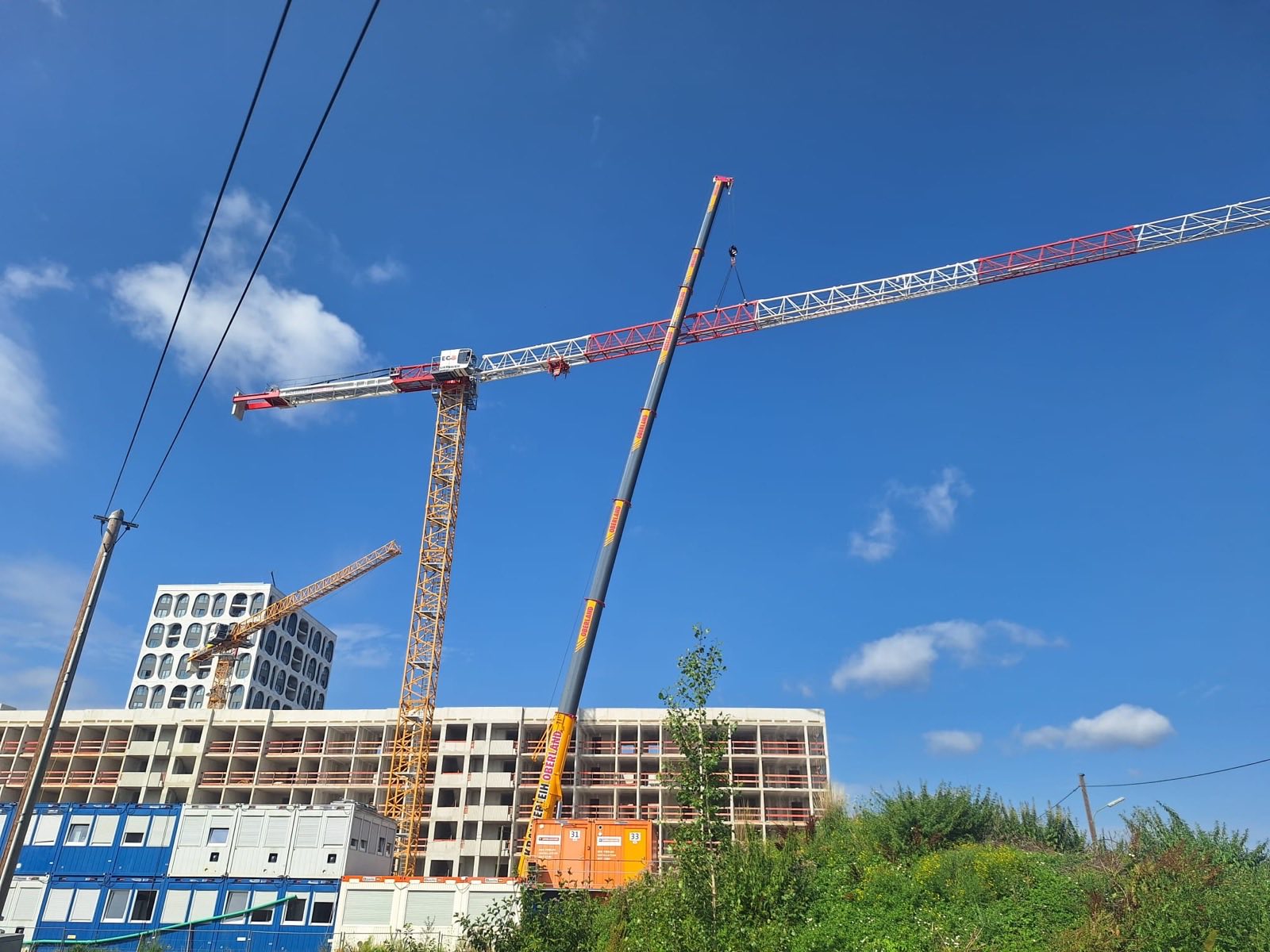 Baustelle in Freiham mit Baucontainern und Kranen im Hintergrund
